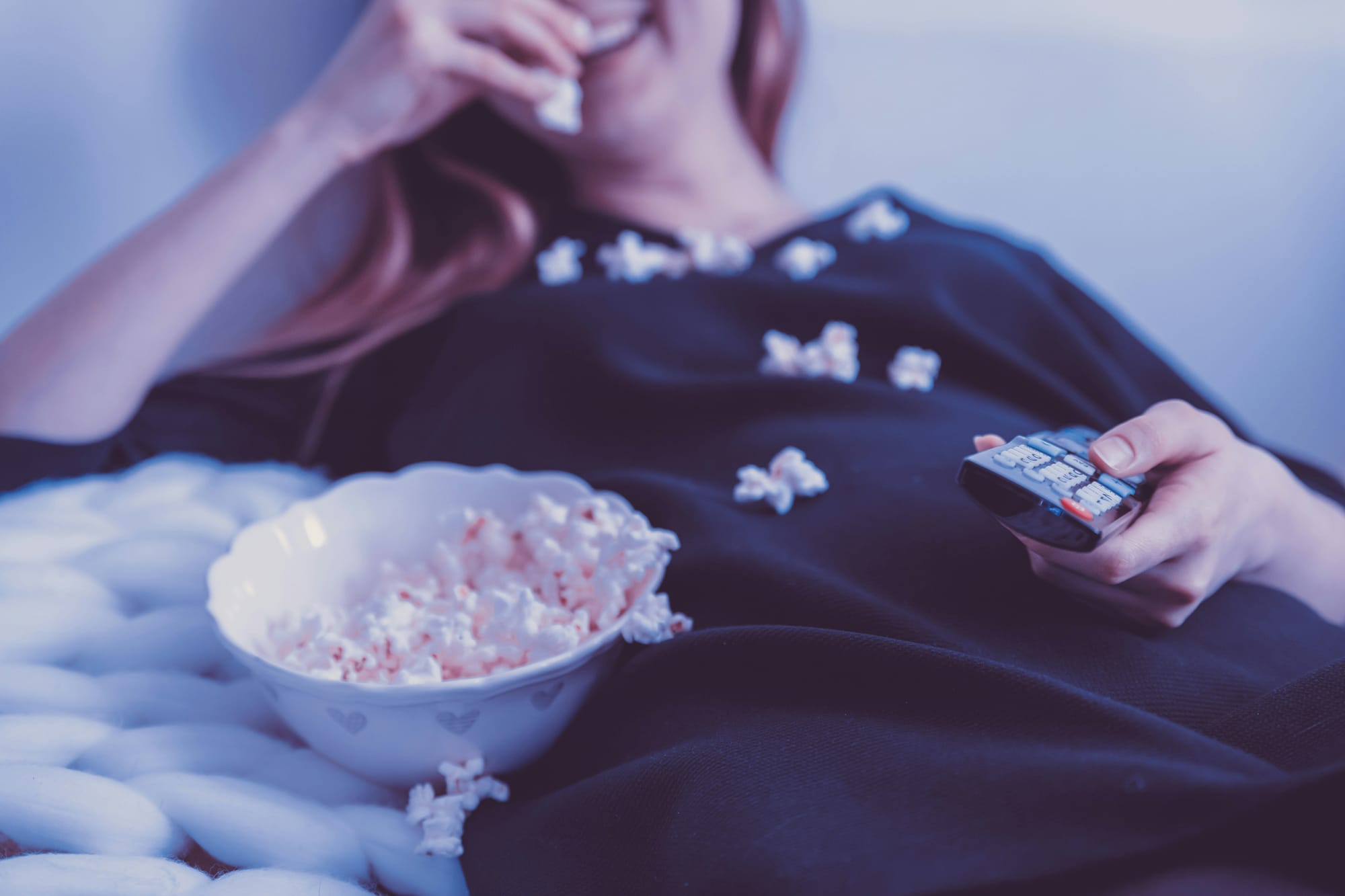 woman eating popcorn and wondering can you watch movies on oculus